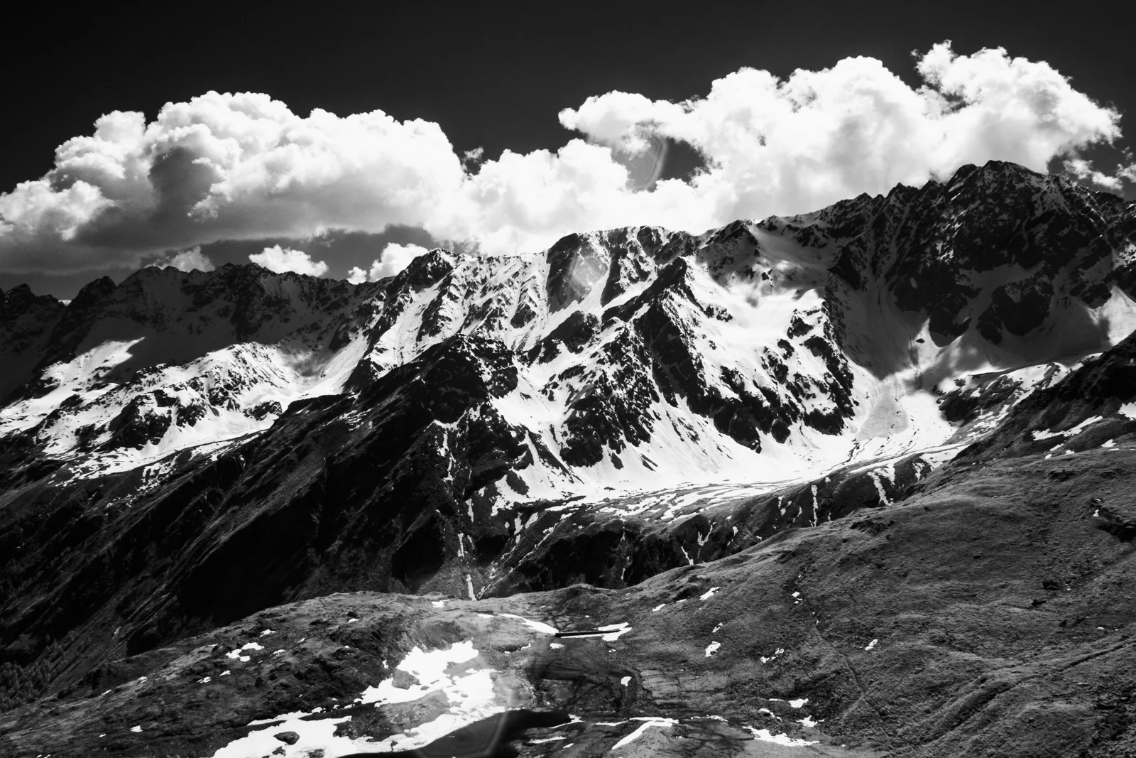 Cime innevate sotto un cielo di nuvole, in bianco e nero